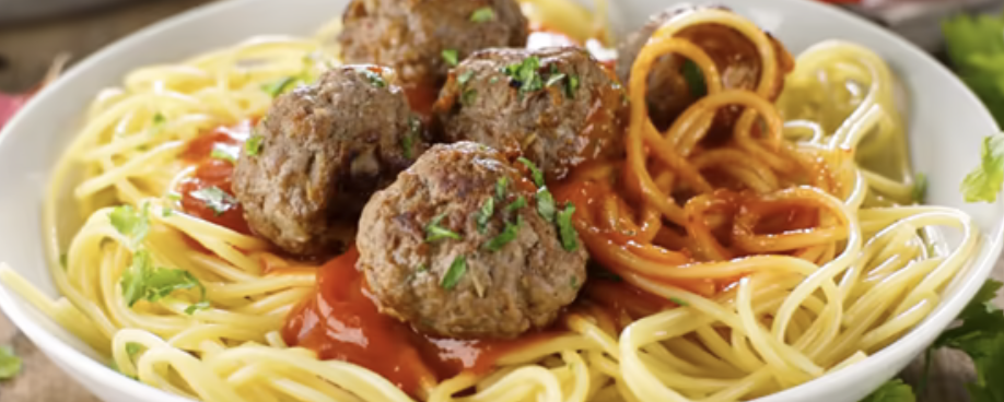 Spaghettis nappés de sauce tomate au basilic avec quatre grosses boulettes dorées au poireau