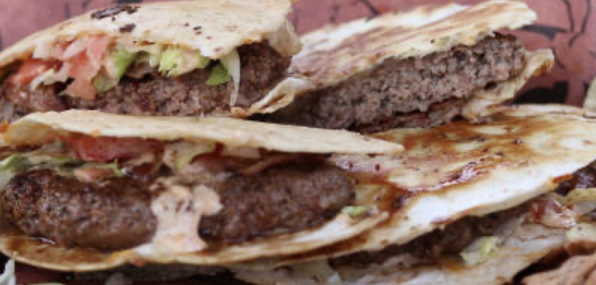 Tacos smash burger sur BBQ garnis de bœuf, laitue et tomates